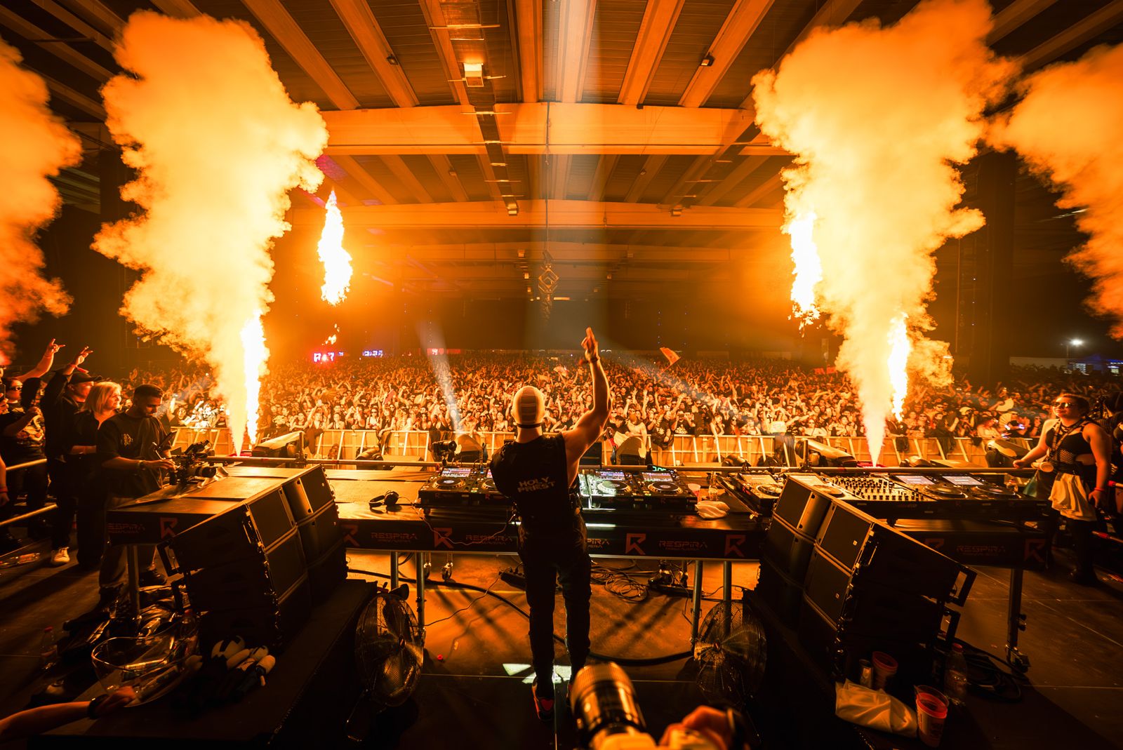 DJ frente a multitud con llamaradas en festival