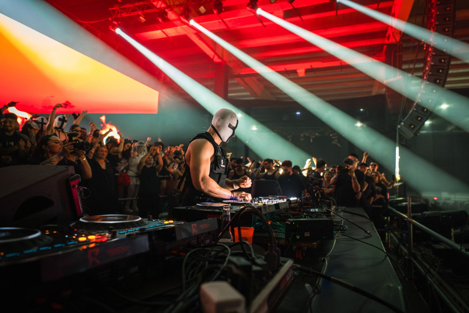 DJ con máscara tocando con luces láser